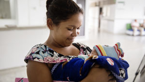 Oscari Pacheio, 19 år från Venezuela ska precis lämna sjukhuset i Cucuta, Colombia med sin son. Hon kom hit som gravid för att hon inte hade råd att köpa all utrustning som behövdes för förlossningen i Venezuela. Kvinna tittar ner på sin bebis som hon har i famnen.