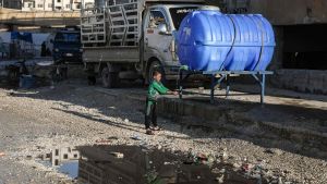 En syrisk pojke tvättar sina händer vid en container i ett läger på fotbollsstadium i i Idlib 3.3.2020. En syrisk pojke tvättar sina händer i ett läger på fotbollsstadium i i Idlib 3.3. 2020.