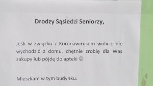 Sådana lappar sitter här och där vid trappuppgångar. Yngre personer vill åta sig att handla eller rasta hundar åt äldre som uppmanas att stanna hemma. En lapp på en dörr med text på polska. Det står att grannar erbjuder att hjälpa till med matuppköp och apoteksbesök