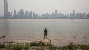 Floden Yangtze och staden Wuhan 3.4.2020 En man vid floden Yangtze tittar på staden Wuhan, Kina. 3.4.2020
