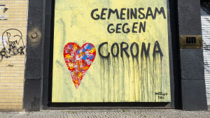 En väggmålning i Berlin med texten tillsammans mot corona