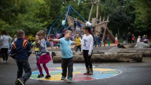 Pojke med Downs syndrom leker på en skolgård. En pojke med Downs Syndrom leker på en skolgård.