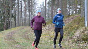 Mikaela Lindgren coh Jonna Öblom joggar fram på spånbanan i Västerby. Två damer kommer löpande på en skogsstig.