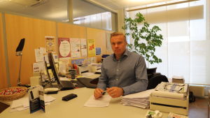 Jouni Ruotsalainen på byggnadsförbundet anser att säkerheten är hög på de flesta arbetsplatser. Medelålders man med ljust hår står bakom skrivbord och tittar in i kameran