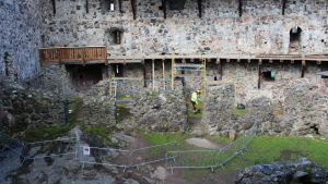 Inne på slottsgården repareras en vattenskadad gångbro. Ungefär hälften av träbron byggs om. slottsgård där renovering pågår
