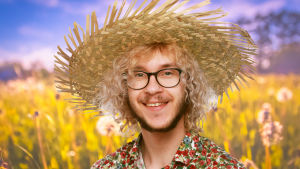 Philip Järvenpää, 20 år gammal sångare och låtskrivare, känd från Vegatoppen och ett stort antal konserter och turnéer runtom i Svenskfinland. Mest känd är han som tolkare av 60-tals musik. Philip Järvenpää ler in i kameran med en stor stråhatt på huvudet. I bakgrunden syns en sommaräng.