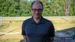 Anders Walls (SFP) är ordförande för stadsstyrelsen i Raseborg. En man med kort hår och pikéskjorta står ute. Sommar.