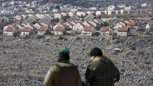 På Västbanken bor förutom palestinier i nuläget också hundratusentals israeliska bosättare. Kuvassa kaksi israelilaispoliisia valvoo etäältä Ofran siirtokuntaa Länsirannalla.