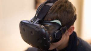 Många blir lätt illamående av att vara inne i den virtuella verkligheten. Då hjälper det att ta en kort paus. Pojke med VR-glasögon.