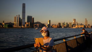 Över 40 procent av alla fall av covid-19 i Hongkong har registrerats under juli-månad. Kvinna i Hongkong med ansiktsskydd tar en selfie med skyskrapor i bakgrunden.