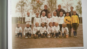Markku Kanerva började spela fotboll som 6-åring och då var det hans pappa som tränade laget. Fotbollslag med 15 barn och 3 vuxna poserar.