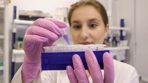Vaccinutvecklingen fick så mycket finansiering att man kunde tillverka vaccinen i stor skala redan innan man visste hur effektiva de var. Kvinna i vid laboratorierock och gummihandskar håller i ett blått kärl med små plastbehållare. Det ryska coronavaccinet tillverkas vid det ryska nationella institutet för epidemiologi och mikrobiologi samt vid läkemedelsfabriker i Ryssland.