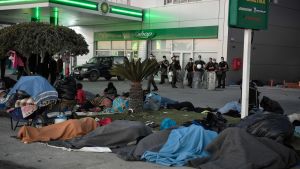 Hemlösa migranter och flyktingar sover på marken vid en bensinstation på Lesbos Hemlösa migranter och flyktingar sover marken vid en bensinstation på Lesbos