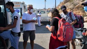 Pino Maggiore (andra till vänster) arbetar både med turister och migranttransporter. Han säger att det behövs mer sjukvårdspersonal och tolkar och färre säkerhetspersonal. Pino Maggiore som arbetar med turister och migranttransporter i Lampedusa.