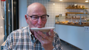En äldre man dricker kaffe på fat