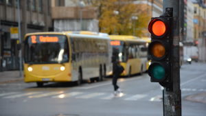 Den här veckan begränsades passagerarmängden i kollektivtrafiken i Egentliga Finland. Syftet är att förhindra virusspridningen i regionen. En buss står vid ett övergångsställe, ett rött trafikljus i förgrunden.
