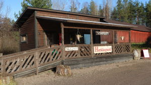 På Mustila gård har det sålts vin i över 20 år. En liten träbyggnad med skylten Viinipuoti.