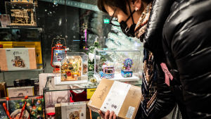 EU vill att shoppande inte styrs enbart till de digitala jättarna i USA. Nainen katselemassa lahjoja joulukaupassa.