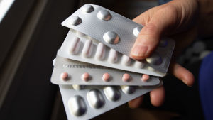 Många finländare äter antidepressiva läkemedel. Försäljningen av psykofarmaka har ökat sedan 2018. En person håller i flera läkemedelskartor i handen.