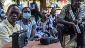 Mohammed Olanyia (till vänster) förlorade hela sin familj i en massaker 2004. Här lyssnar han på radio där ICC-domstolen dom mot krigsherren Dominic Ongwen kungörs (4.2.2021). Mohammed Olanyia (till vänster) förlorade hela sin familj i en massaker 2004. Här lyssnar han (4.2.2021) på ICC-domstolen dom mot krigsherren Dominic Ongwen