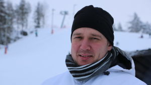 Mats Nordgren En man med svart mössa och halsduk. I bakgrunden syns en skidbacke.