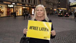 Tiina Jauhiainen med en skylt där det står "Befria Latifa" Tiina Jauhiainen med en skylt där det står "Befria Latifa"