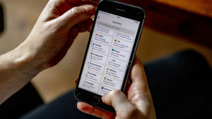 Så här ser det ut då man surfar bland intressen och samtalsämnen i appen. EN hand som håller i en telefon och på skärmen syns Clubhouse-appen.
