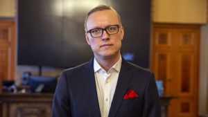 Stadsdirektör Jukka-Pekka Ujula. Medelålders man i mörkblå kostym i en festsal.