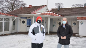 Nikolai Sumelius och Tomas Eklund är båda positivt inställda till planerna för gästhamnen. Två män i munskydd fram för ett hus.