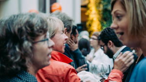 Mingel och informella samtal är otroligt viktiga. Ibland inser man nyttan av dem först efteråt. (Bilden är från konferensen pbi2019 i Helsingfors) Flera personer minglar och pratar med varandra på en informell sammankomst i samband med en konferens.