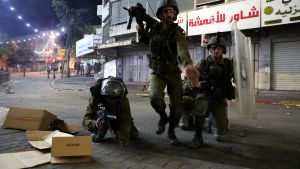 Israel har skickat förstärkning till flera städer. Tre personer i militärutrustning med tunga vapen.