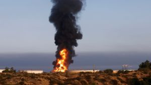 Oljeraffinaderiet i den israeliska staden Ashkelon brann på onsdagsmorgonen efter att ha träffats av Hamasraketer. Tjock svart rök stiger upp från en låg byggnad vid havet.