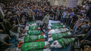 Hundratals sörjande var samlade då 15 palestinier begravdes på tisdagen. Sörjande står samlade kring 15 insvepta kroppar.