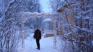 Hasse utanför sitt hus. Hans Wikström utanför sitt gula egnahemshus i centrum av Tenala. Vinter och snö.