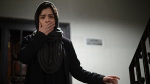 Hur kunde det här hända? Rana (Taraneh Alidoosti) är förskräckt över följderna av det som hänt sedan hon blev överfallen. Rani står i trappan med handen framför munnen av rädsla.