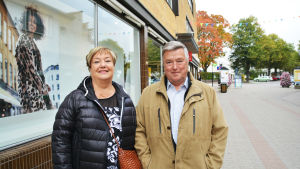 Magga och Carl Franck handlar inte så ofta kläder men de köper dem gärna i närregionen. En man och en kvinna står på en gågata brevid ett skyltfönster.