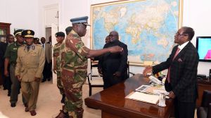 Robert Mugabe skakar hand med militära ledare strax innan han ska hålla tal. Robert Mugabe skakar hand med ledare för armén inför förhandlingar 19.11.2017.