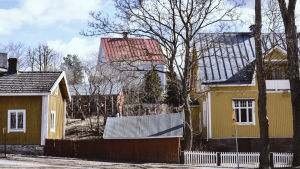 Det finns flera hus som är över hundra år gamla på området. Puutaloja kadun varrella, taaemmalla ylempänä rinteessa, kuva otettu talvella, puissa ei lehtiä.