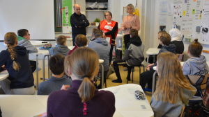 Eleverna väntar spänt på att få höra Mustapha Achkirs livshistoria. Tre vuxna står framför en fullsatt klass