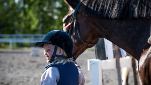 Ridning är en dyr hobby som ytterst få barn har möjlighet till. En flicka leder en stor häst.