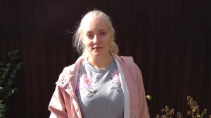 Lina-Lotta Lundström är 15 år och går på högstadiet i Ekenäs. flicka mot mörkröd bakgrund
