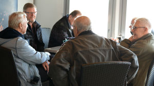 Runt bordet bland annat Hans Lönnberg, Risto Orpana och Stig Sundberg. män kring cafebord