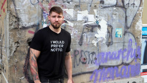 Weissgerbers tatueringar täcker tidigare tatueringar, bland annat hakkors. Porträtt på Christian Weissgerber framför en vägg fylld av graffiti.