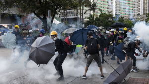 De tio veckor långa protesterna har blivit allt oroligare medan polisen har tagit i bruk allt hårdare metoder så som tårgas och vattenkanoner Demonstranter i Hongkong skyddar sig från polisens tårgaspatroner med paraplyn.