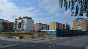 Snart blir det byggstart för fyra nya hus på tomten där Centrumhuset fanns tidigare. Byggnadsområde i vasa. I förgrunden ett urgrävt område för ett nytt hus. I bakgrunden en rad med bostadshus.