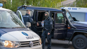 En stor mängd poliser och polisfordon samlades vid Estbacka daghem under jakten på bröderna. Poliser vid polisbil.