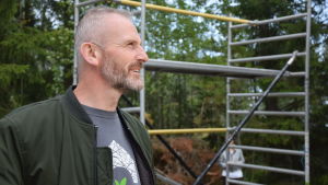 Finns inget mer tillfredsställande än att se när ett långvarigt projekt börjar ta form. Paul Lynch hittar inga andra nackdelar med hus byggt i halm än att det inte får regna när huset monteras. Som ägare till byggbolaget är han förstås också mån om att lyfta fram fördelar framom nackdelar. En man med skägg och gråsprängt hår följer med ett husbygge.