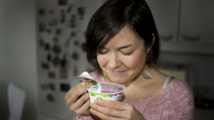 Mira Metsälehto haistelee rahkapurkkia.