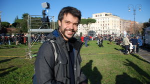 Andrea Garreffa är cykelguiden som tillsammans med några vänner startat en rörelse som tagit sådan fart att ingen vet vart det kan sluta. Närbild av en man som ler och står på en gräsmatta i en stad.