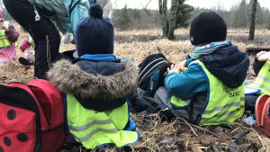 I lekskolan Sockan går barnen till mulleskogen regelbundet. barn sitter på piknik i skogen
